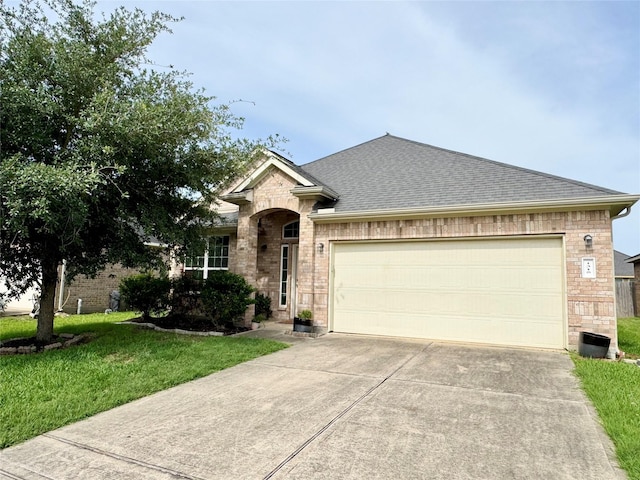 1315 Maple Ace Dr, Katy, TX 77493 - french country style house featuring driveway, a garage, roof with shingles, a front yard, and brick siding