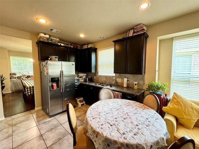 1315 Maple Ace Dr, Katy, TX 77493 - kitchen featuring stainless steel fridge with ice dispenser, dark countertops, backsplash, light tile patterned flooring, and recessed lighting