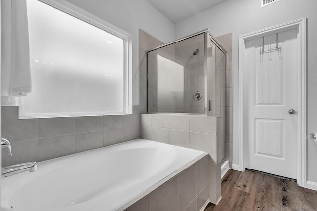 25424 Grotto Falls Ln, Porter, TX 77365 - bathroom with a garden tub, a stall shower, and wood finished floors