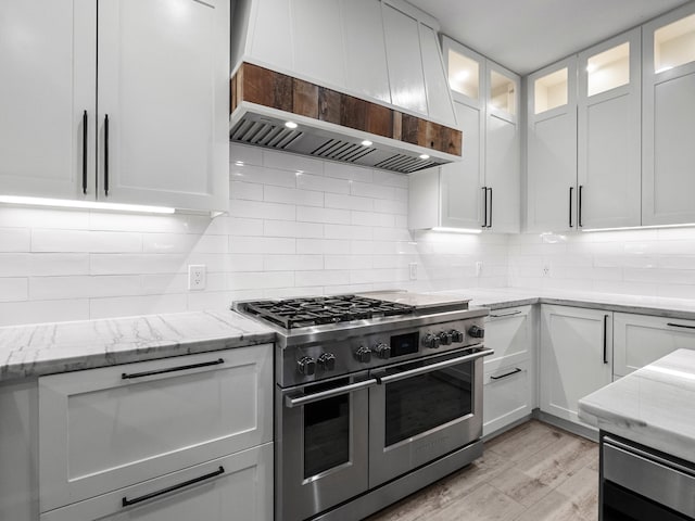 2965 Rustic Pier Ln, League City, TX 77573 - kitchen with double oven range, custom exhaust hood, white cabinetry, and light wood-style flooring