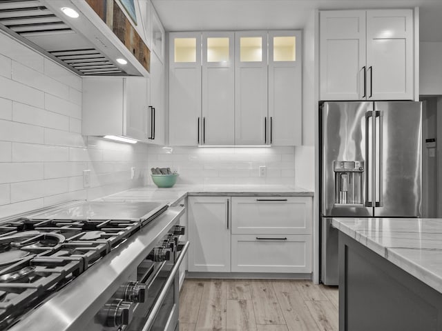 2965 Rustic Pier Ln, League City, TX 77573 - kitchen with custom exhaust hood, stainless steel appliances, light stone countertops, and white cabinets