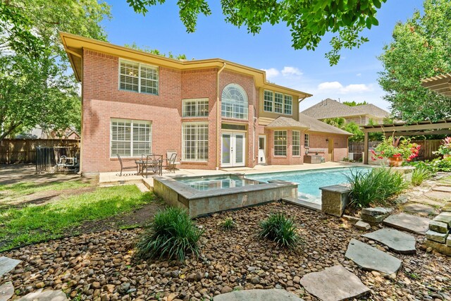 1915 Landon Point Cir, Katy, TX 77450 - back of house featuring french doors, an in-ground hot tub, brick siding, a pergola, and a patio