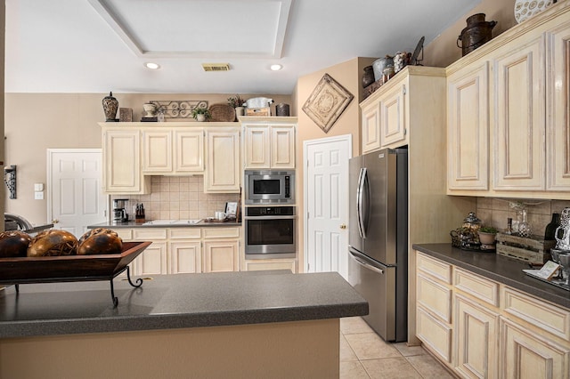 10235 Shipmans Landing Dr, Missouri City, TX 77459 - kitchen with appliances with stainless steel finishes, dark countertops, backsplash, recessed lighting, and cream cabinets