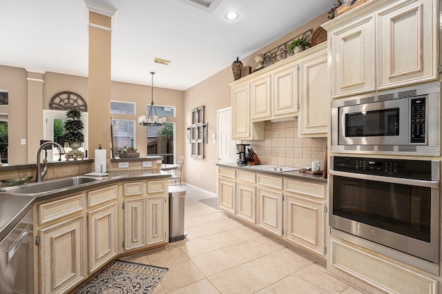 10235 Shipmans Landing Dr, Missouri City, TX 77459 - kitchen with stainless steel appliances, a sink, cream cabinets, backsplash, and recessed lighting