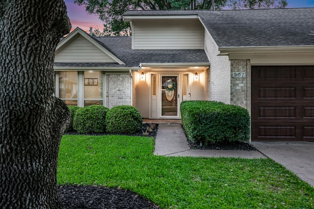 907 Eva Dr, Katy, TX 77493 - view of front of property with a shingled roof, brick siding, an attached garage, and a lawn
