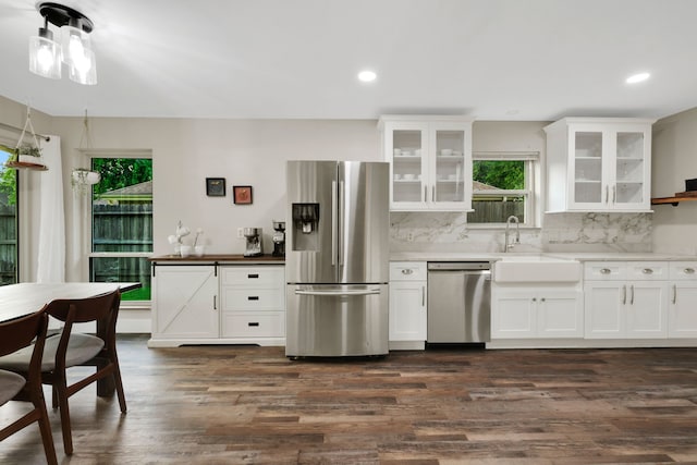 907 Eva Dr, Katy, TX 77493 - kitchen with appliances with stainless steel finishes, dark wood-style floors, backsplash, a sink, and white cabinets