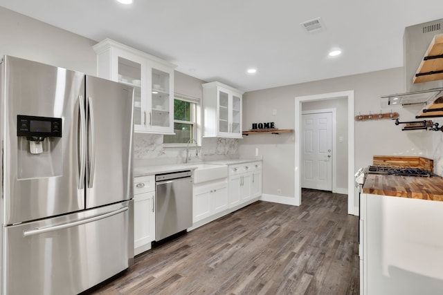 907 Eva Dr, Katy, TX 77493 - kitchen with appliances with stainless steel finishes, wood counters, open shelves, dark wood-type flooring, and decorative backsplash