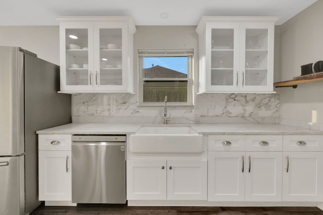 907 Eva Dr, Katy, TX 77493 - kitchen with stainless steel appliances, a sink, white cabinetry, backsplash, and light stone countertops