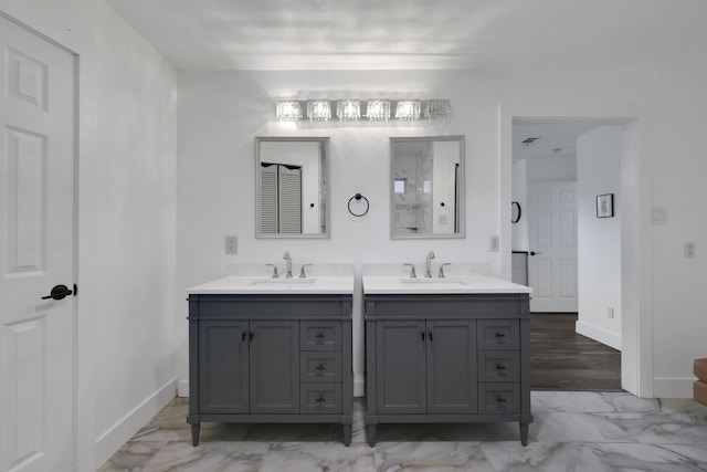 907 Eva Dr, Katy, TX 77493 - bathroom with double vanity, marble look tiles, and baseboards