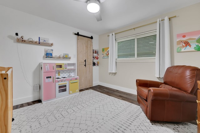 907 Eva Dr, Katy, TX 77493 - sitting room with wood finished floors, a barn door, and baseboards