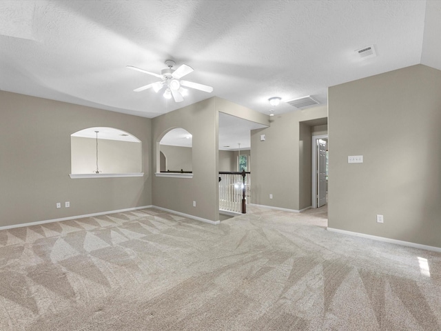 25169 Nutley Cir, Porter, TX 77365 - empty room with light carpet, a ceiling fan, baseboards, and a textured ceiling
