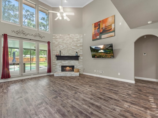 25169 Nutley Cir, Porter, TX 77365 - unfurnished living room featuring arched walkways, a high ceiling, a ceiling fan, wood finished floors, and baseboards