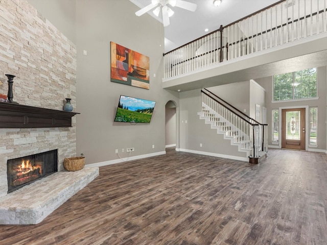 25169 Nutley Cir, Porter, TX 77365 - unfurnished living room with a high ceiling, baseboards, stairway, wood finished floors, and ceiling fan