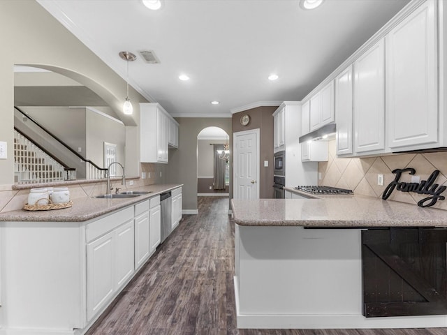 25169 Nutley Cir, Porter, TX 77365 - kitchen featuring arched walkways, a sink, a peninsula, white cabinetry, and ornamental molding