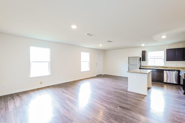 2722 Stallings Dr, Houston, TX 77088 - kitchen featuring freestanding refrigerator, dishwasher, a center island, wood finished floors, and open floor plan