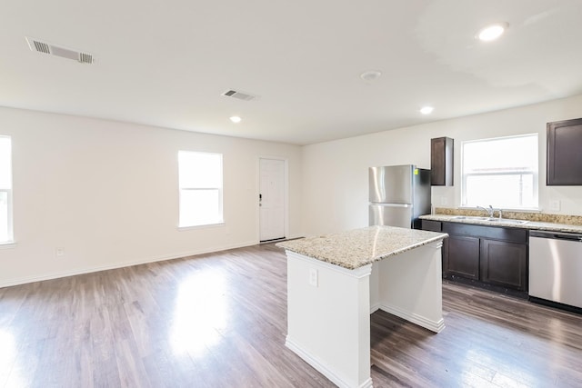2722 Stallings Dr, Houston, TX 77088 - kitchen with appliances with stainless steel finishes, plenty of natural light, a center island, wood finished floors, and recessed lighting