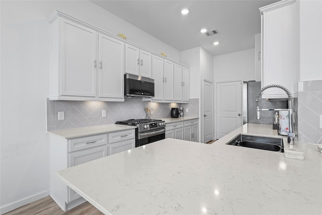 4050 Champlain Way, Rosharon, TX 77583 - kitchen with stainless steel appliances, a sink, white cabinets, decorative backsplash, and recessed lighting