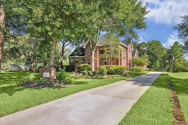 2215 Timbershade Ct, Magnolia, TX 77355 - view of front of home featuring brick siding, a front lawn, and driveway