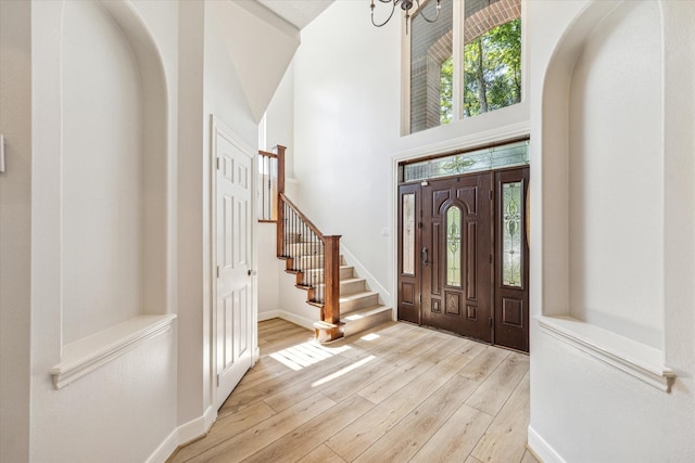 2215 Timbershade Ct, Magnolia, TX 77355 - foyer featuring stairs, wood finished floors, baseboards, arched walkways, and a high ceiling