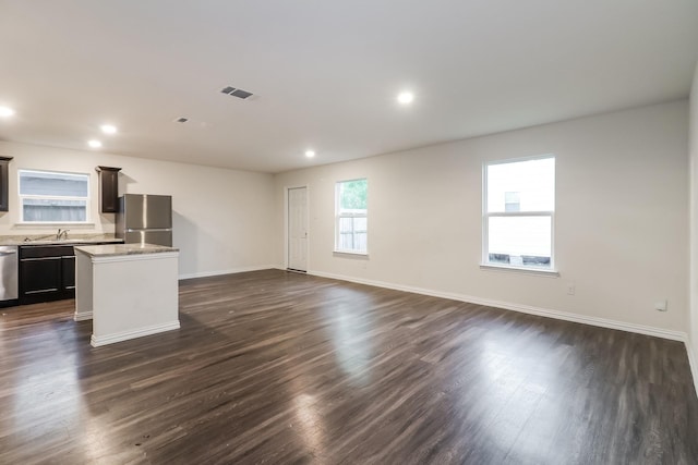 9721 Stedman St, Houston, TX 77029 - unfurnished living room featuring baseboards, dark wood-type flooring, a sink, and recessed lighting