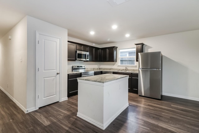 9721 Stedman St, Houston, TX 77029 - kitchen featuring stainless steel appliances, dark wood-style floors, a kitchen island, a sink, and recessed lighting