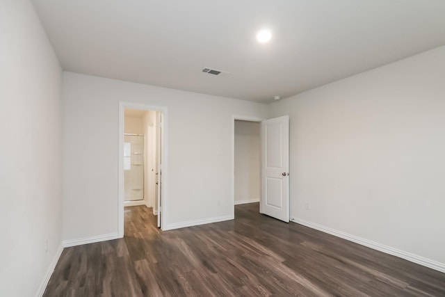 9721 Stedman St, Houston, TX 77029 - unfurnished bedroom featuring dark wood-type flooring, baseboards, and connected bathroom