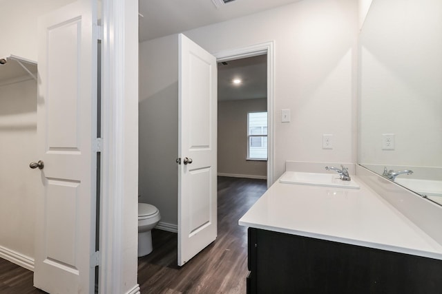 9721 Stedman St, Houston, TX 77029 - bathroom featuring toilet, wood finished floors, vanity, and baseboards
