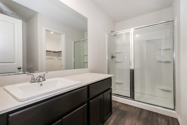 9721 Stedman St, Houston, TX 77029 - bathroom with a shower stall, wood finished floors, vanity, and a walk in closet