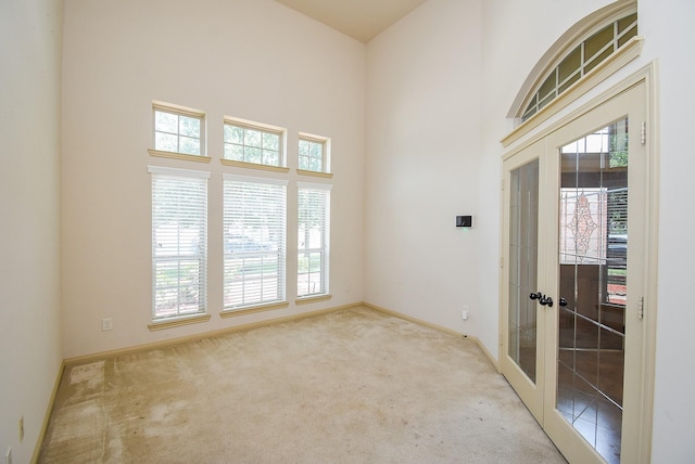 2614 Palm Harbour Dr, Missouri City, TX 77459 - carpeted spare room featuring french doors, a towering ceiling, and baseboards