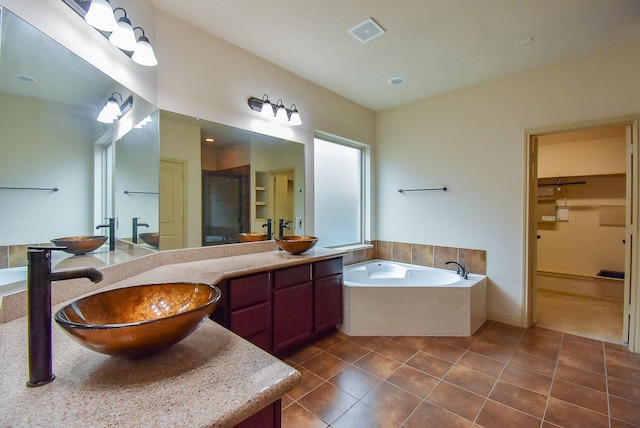 2614 Palm Harbour Dr, Missouri City, TX 77459 - full bathroom with a walk in closet, double vanity, a bath, tile patterned floors, and a shower stall