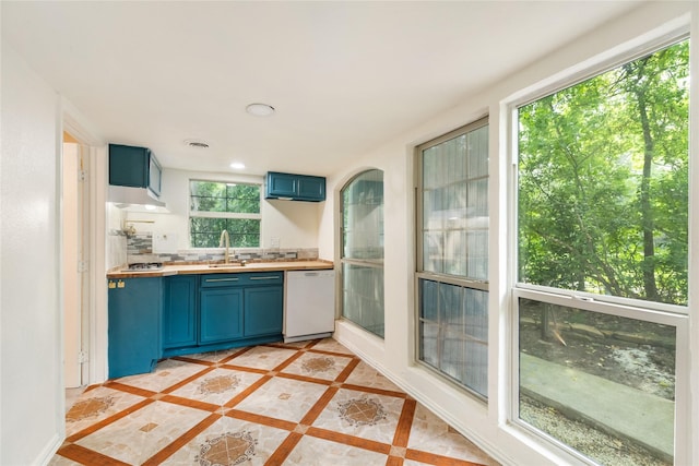 13 Whistlers Ct, The Woodlands, TX 77380 - kitchen with white dishwasher, blue cabinets, a sink, wood counters, and recessed lighting