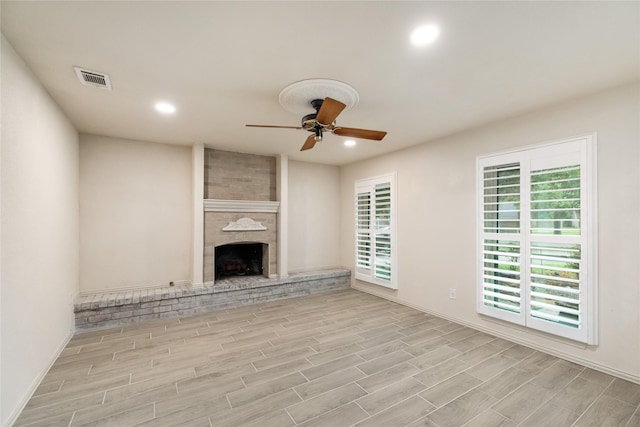 13 Whistlers Ct, The Woodlands, TX 77380 - unfurnished living room with a ceiling fan, light wood-style floors, recessed lighting, a brick fireplace, and baseboards