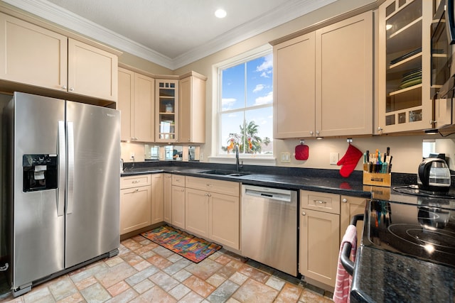 1854 Tiki Dr, Tiki Island, TX 77554 - kitchen featuring stainless steel appliances, cream cabinetry, a sink, crown molding, and glass insert cabinets