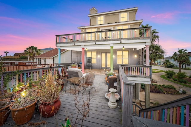 1854 Tiki Dr, Tiki Island, TX 77554 - rear view of house featuring a balcony, french doors, a chimney, and a deck