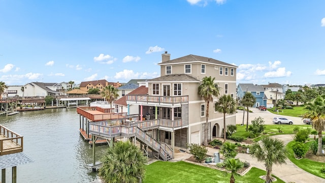 1854 Tiki Dr, Tiki Island, TX 77554 - dock featuring a water view, a residential view, stairs, a lawn, and a balcony