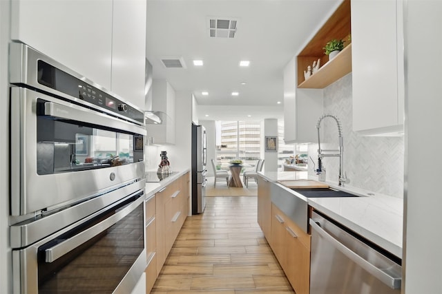 5110 San Felipe St Unit 97W, Houston, TX 77056 - kitchen with modern cabinets, appliances with stainless steel finishes, a sink, tasteful backsplash, and recessed lighting