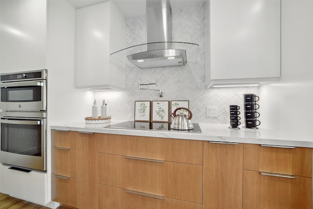 5110 San Felipe St Unit 97W, Houston, TX 77056 - kitchen featuring wall chimney exhaust hood, double oven, black electric stovetop, and modern cabinets