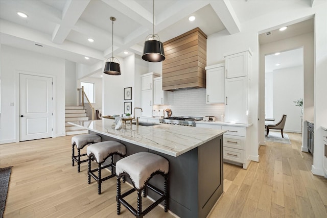 1115 Potomac Dr Unit B, Houston, TX 77057 - kitchen with a sink, a breakfast bar area, light wood finished floors, custom exhaust hood, and beam ceiling