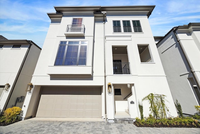 1115 Potomac Dr Unit B, Houston, TX 77057 - view of front facade with stucco siding, a balcony, an attached garage, and decorative driveway