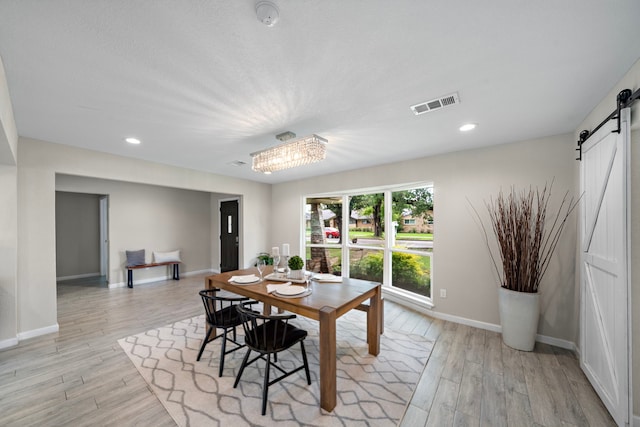 4003 Mischire Dr, Houston, TX 77025 - dining room with a barn door, light wood-type flooring, baseboards, recessed lighting, and a chandelier