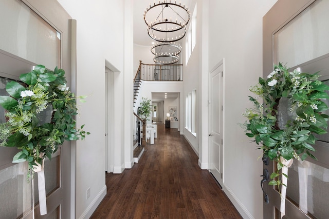 74 N Curly Willow Cir, Tomball, TX 77375 - foyer entrance with a chandelier, a towering ceiling, dark wood-type flooring, and baseboards