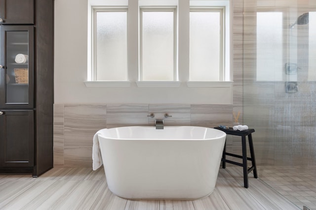 74 N Curly Willow Cir, Tomball, TX 77375 - bathroom with tile walls, healthy amount of natural light, tiled shower, a freestanding tub, and wainscoting