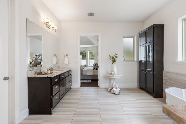 74 N Curly Willow Cir, Tomball, TX 77375 - bathroom featuring ensuite bath, vanity, a freestanding tub, baseboards, and tile patterned flooring