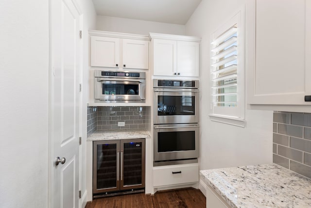 74 N Curly Willow Cir, Tomball, TX 77375 - kitchen with wine cooler, double oven, decorative backsplash, and white cabinets