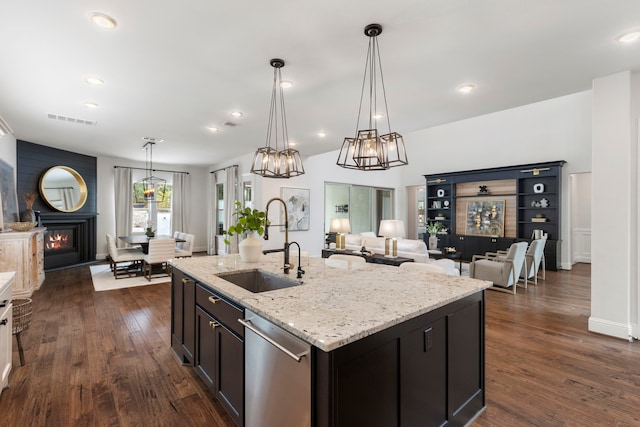 74 N Curly Willow Cir, Tomball, TX 77375 - kitchen featuring dishwasher, a sink, dark wood-style flooring, light stone countertops, and pendant lighting