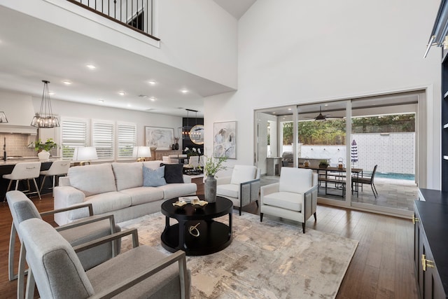 74 N Curly Willow Cir, Tomball, TX 77375 - living room featuring a chandelier, wood-type flooring, a towering ceiling, and recessed lighting