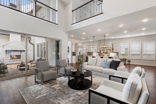 74 N Curly Willow Cir, Tomball, TX 77375 - living room with wood finished floors, a warm lit fireplace, baseboards, and a high ceiling