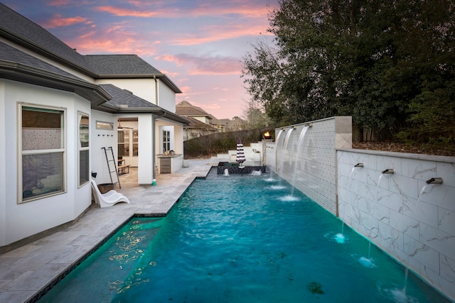 74 N Curly Willow Cir, Tomball, TX 77375 - pool at dusk featuring a patio area and a fenced backyard