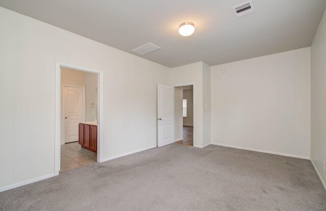 3102 Gianna Springs Ct, Humble, TX 77396 - unfurnished bedroom featuring light carpet, baseboards, and ensuite bath