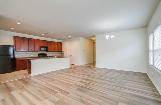 3102 Gianna Springs Ct, Humble, TX 77396 - kitchen featuring black appliances, light wood finished floors, tasteful backsplash, a chandelier, and hanging light fixtures